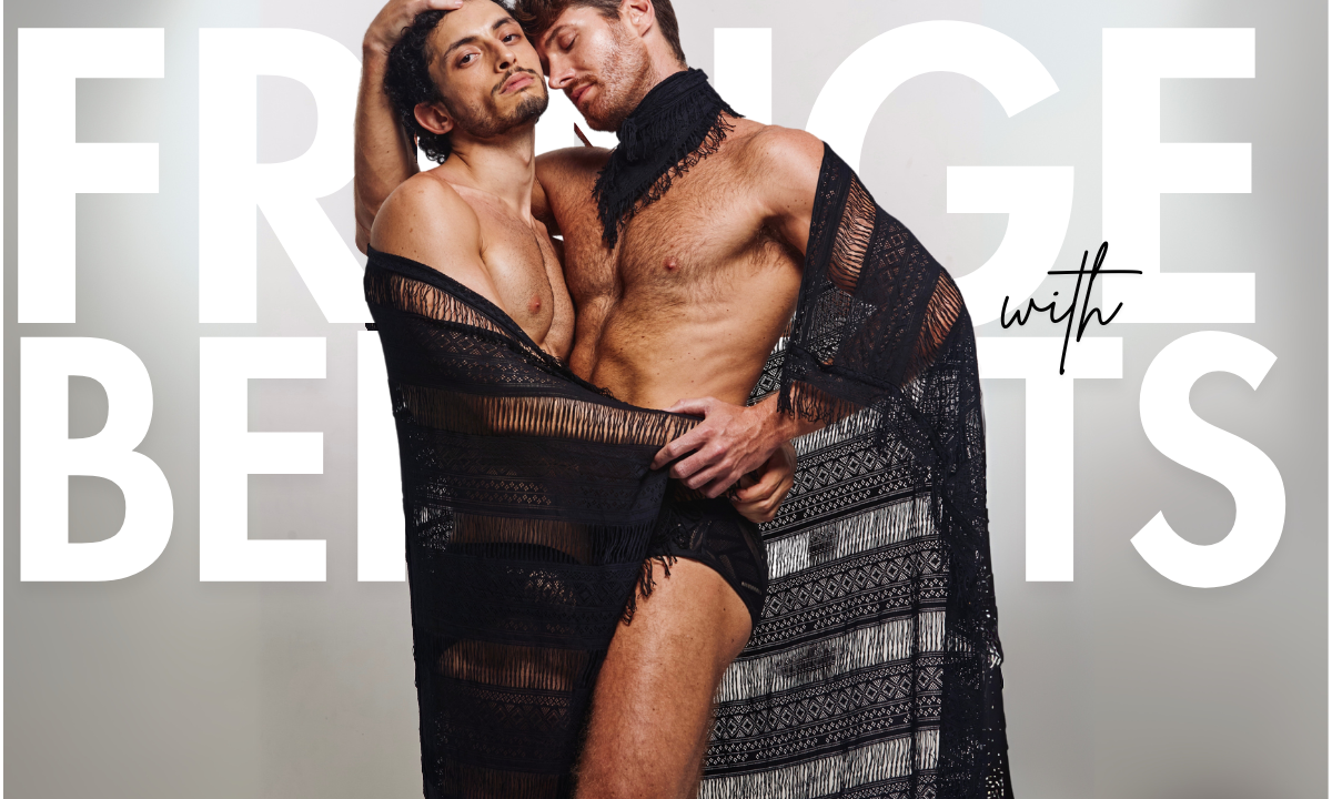 Models wearing black lace fringe sarong and black lace fringe bandana from WONGSO’s Fringe With Benefits collection, standing against a dark textured background with dramatic lighting highlighting the sheer fabric and silhouette.